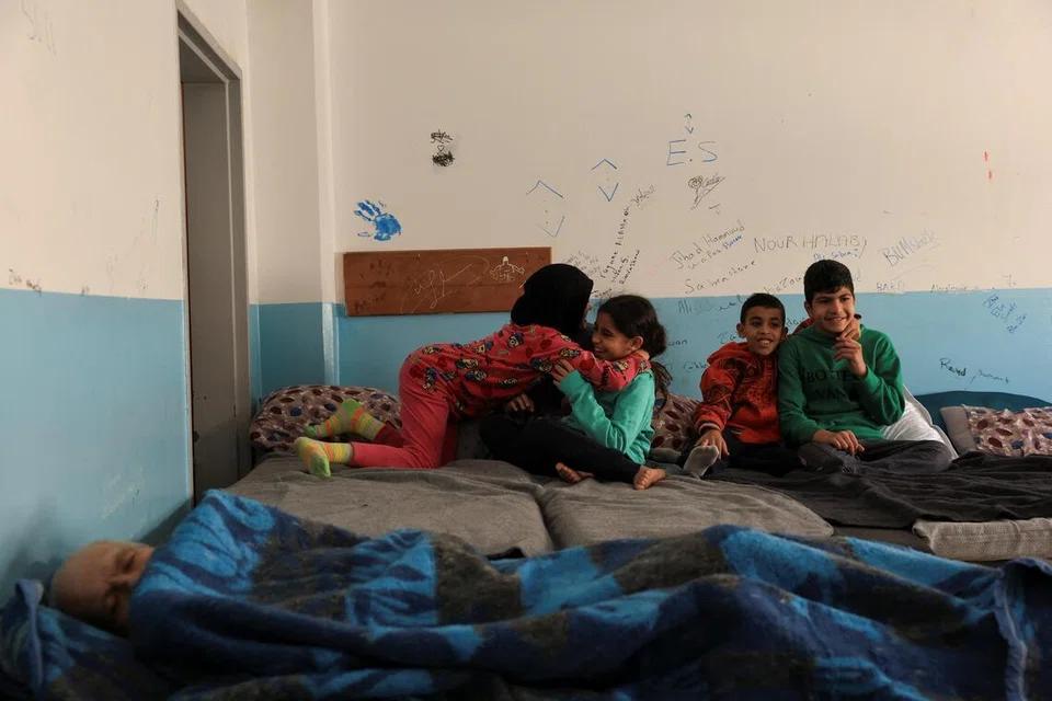 லெபனானில் இடம்பெயர்ந்துள்ள குடும்பங்களுக்குத் தற்காலிக தங்குமுகாமாக மாற்றப்பட்ட பள்ளி வளாகத்தில் திங்கட்கிழமை (மார்ச் 17) குழந்தைகள் விளையாடுகின்றனர். 