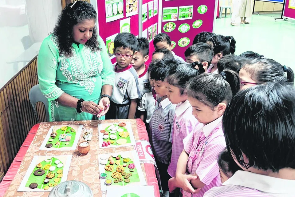 மாணவர்களுக்கு சூச்சின் பள்ளி தமிழ் ஆசிரியர் உணவுகள் பற்றி விளக்கம் அளிக்கிறார்.