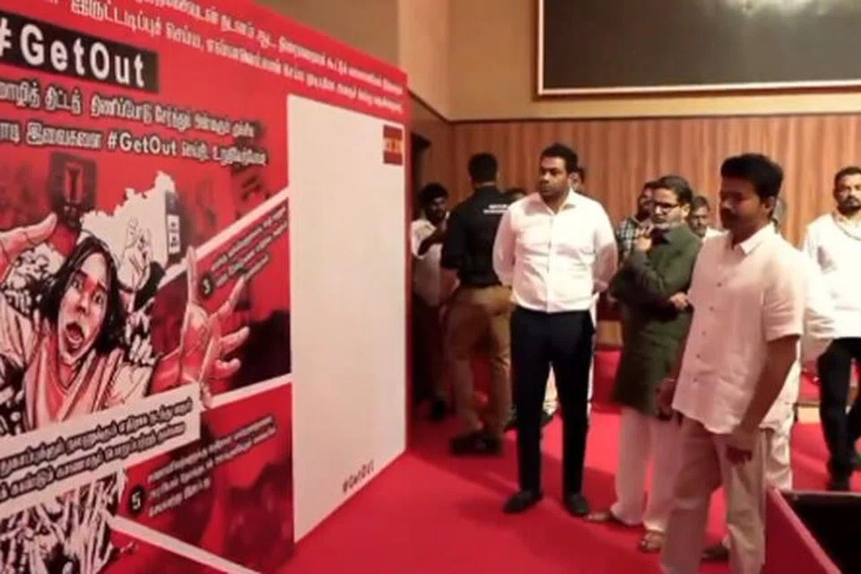 மேடைக்கு அருகே வைக்கப்பட்டிருந்த மும்மொழி கொள்கை, மாநில, மத்திய அரசு ஆகியவற்றிற்கு எதிரான வாசகங்கள் அடங்கிய பதாகையைக் கையெழுத்திடுவதற்குமுன் பார்வையிட்ட விஜய்.