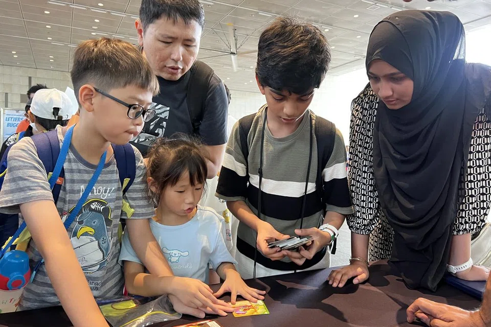 சிறுவர்கள் தம் அட்டைகளைப் பரிமாற்றிக்கொள்ளலாம். படத்தில், தன் அக்காவுடன் தாஜுதீன் (வலமிருந்து இரண்டாவது).