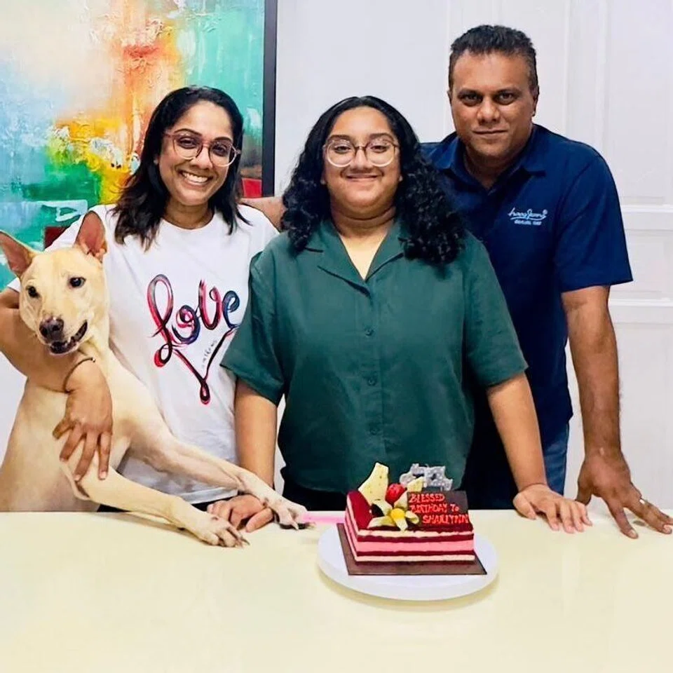 ஷார்லின் ஜான் சேரனும் (நடுவில்) அவரது பெற்றோர் சந்தியா சண்மு௧மும் 45, ஜான் சேரனும், 47.