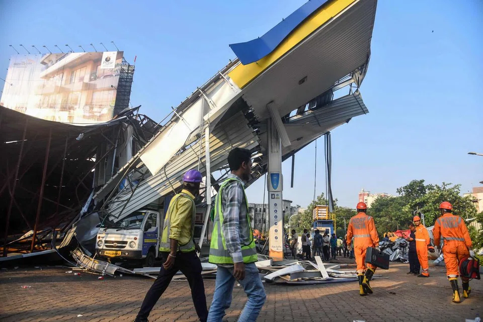 சாலையோரம் வைக்கப்பட்ட பெரிய விளம்பரப் பலகை அங்கிருந்த சில வீடுகள், பெட்ரோல் நிலையம் மீது விழுந்தது. 
