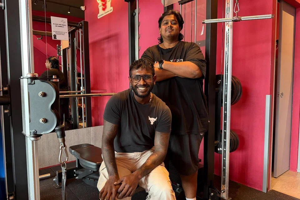 உடற்பயிற்சிக் கூடத்தில் பயிற்றுவிப்பாளர் விக்னேஷுடன் (அமர்ந்திருப்பவர்) ஹரேஷ் சுரேஷ்.