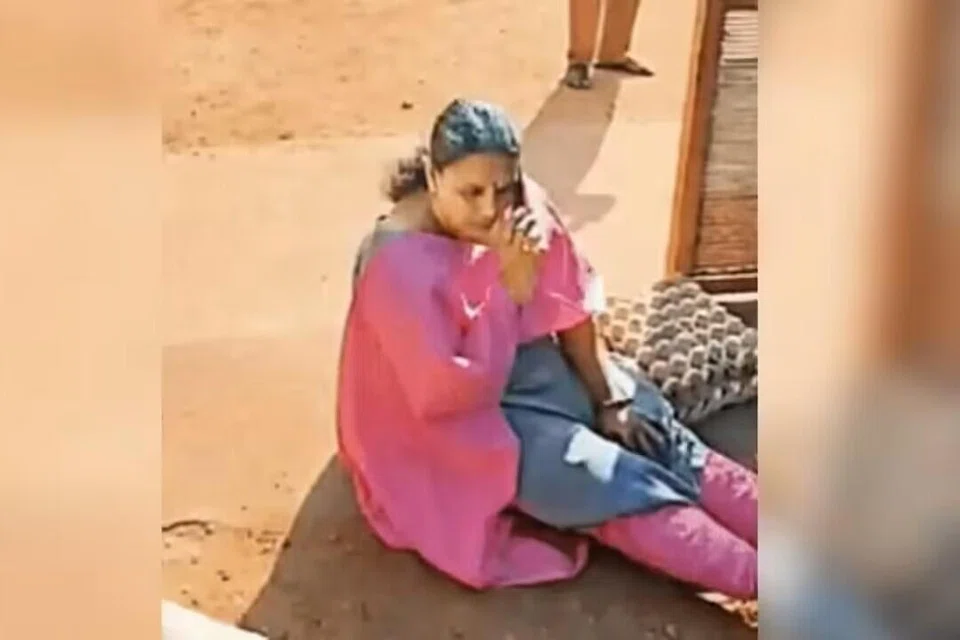 பள்ளி வாயிலுக்கு முன்பாக அமர்ந்து போராட்டத்தில் ஈடுபட்ட தலைமை ஆசிரியை சுதா எஸ் நாயர்.