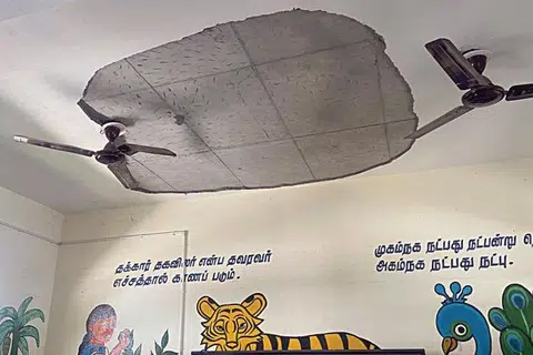 அரசுப் பள்ளி வகுப்பறையின் மேற்கூரையில் உள்ள சிமென்ட் பூச்சு பெயர்ந்து கொட்டியது.