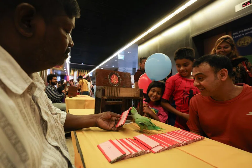 அக்டோபர் 5ஆம் தேதி வருகை தந்திருந்த கிளி சோதிடரிடம் குறி கேட்டு மகிழும் ஒரு குடும்பம்.
