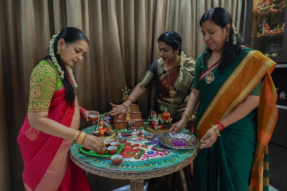 அழகுக் கைவினைகள் நிறைந்த கல்யாணி கோபாலின் (ஆக இடது) வீட்டில் ‘பொங்கல் கொலு’வை அமைக்க அவருக்கு நண்பர்களான பிரபாவதி சிங்காரம் (நடுவில்), புவனேஷ்வரி மங்களேஷ்வரன் ஆகியோர் உதவுகின்றனர். இறை, இயற்கை, உழவு ஆகியவற்றைப் போற்றுவது இதன் நோக்கம் என அவர்கள் கூறுகின்றனர்.