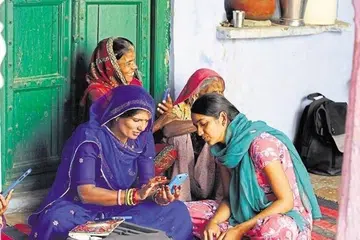  இந்தியக் கிராமம் ஒன்றில் திறன்பேசியைப் பயன்படுத்திய பெண்கள்.