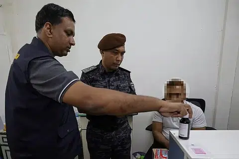உரிமம் பெறாத மருந்தகத்தில் வெளிநாட்டவர் ஒருவர் வழங்கிய மருந்தைச் சுகாதார அமைச்சு அதிகாரி ஒருவருடன் இணைந்து சோதிக்கிறார் குடிநுழைவுத் துணைத் தலைமைச் செயல்பாட்டு இயக்குநர் லோக்மான் எஃபண்டி ராம்லி (நடுவில்).