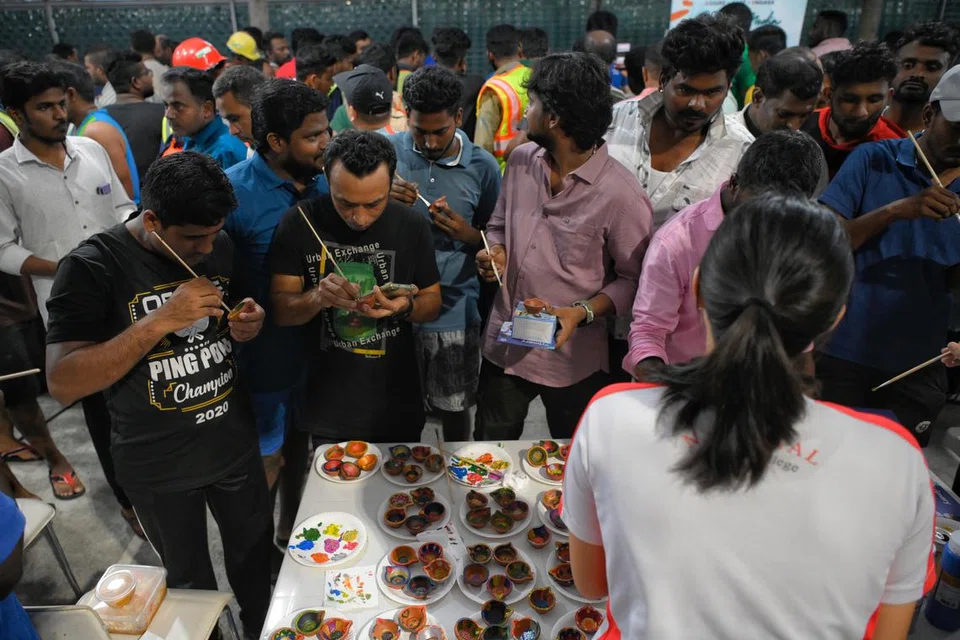 விளக்குகளுக்குச் சாயம் பூசி தீபாவளியை வரவேற்ற வெளிநாட்டு ஊழியர்கள்.