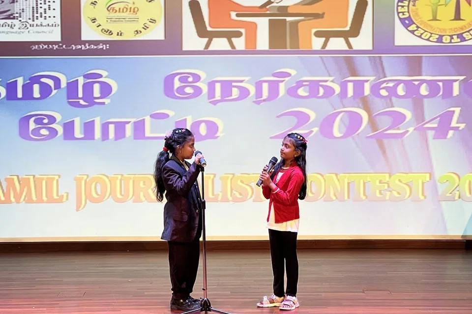 தமிழ் நேர்காணல் போட்டியில் பாலர் பள்ளி முதல் தொடக்கநிலை 3 வரையிலான பிரிவில் வென்ற நேஹாஸ்ரீ (இடம்) சக மாணவரைப் பேட்டி காண்கிறார்.