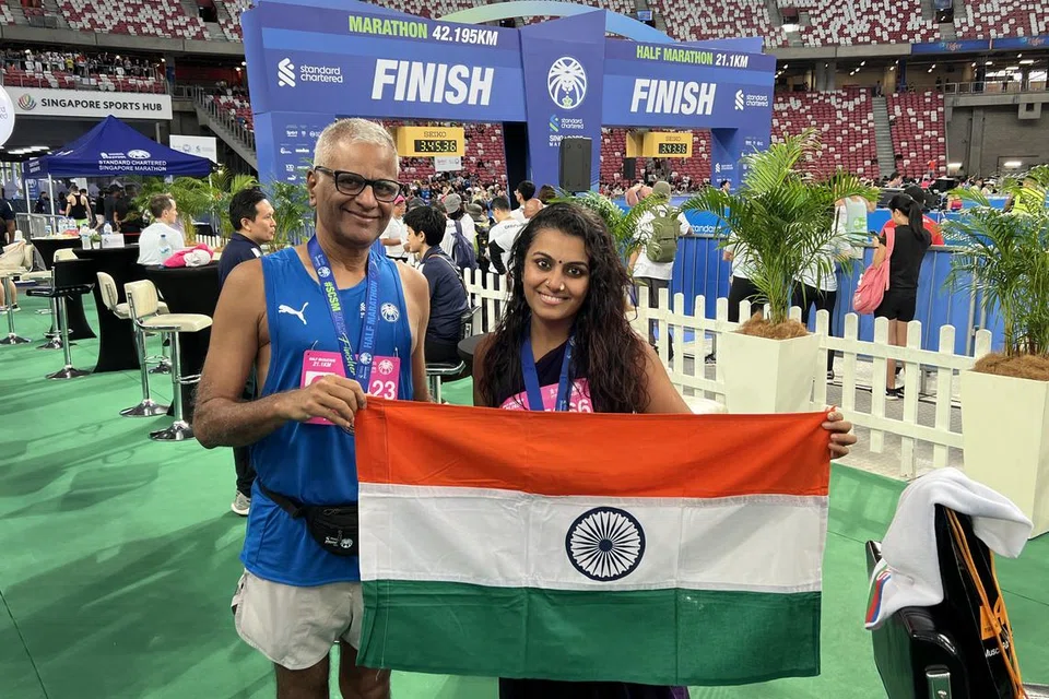 சேலையில் ஓடி அரை நெடுந்தொலைவோட்டத்தை முடித்த இந்தியர் ஸ்வாதி முகுந்த், 35 (வலது), அவரது தந்தை சுப்பிரமணியம் மஹாதேவன், 66.