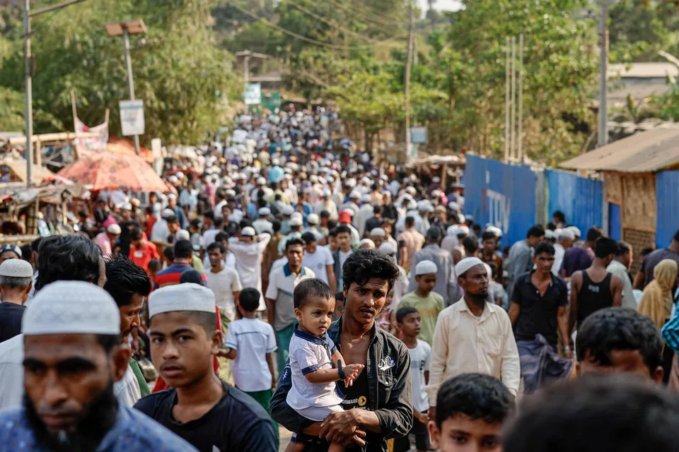 பங்ளாதே‌ஷில் உள்ள அகதிகள் முகாமில் உணவுக்காகக் காத்திருக்கும் ரோஹிங்யா அகதிகள்.