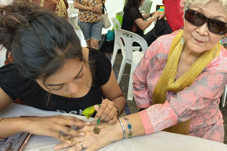 சிராங்கூனிலுள்ள சன்லவ் பராமரிப்பு நிலையத்தின் தீபாவளிக் கொண்டாட்டத்தில் மூதாட்டி ஒருவரின் கையில் மருதாணி வரையப்படுகிறது.