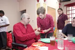 நிகழ்ச்சியில் பங்கேற்ற முதியவர் ஒருவருக்கு ‘ஹங் பாவ்’ உறை வழங்கும் தகவல், மின்னிலக்க மேம்பாட்டு அமைச்சர் ஜோசஃபின் டியோ.