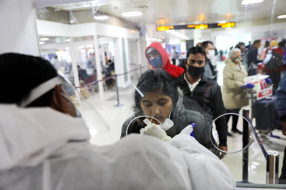 டெல்லி அனைத்துலக விமான நிலையத்தில் கொவிட்-19 பரிசோதனைக்கு உட்படுத்தப்படும் பயணி.