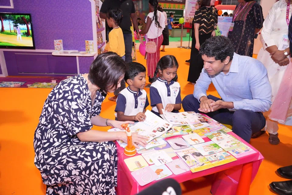 ‘படிப்போம், புத்தக வானில் பறப்போம்’ முன்னோட்டத் திட்டத்தில் பங்குபெறும் குவீன்ஸ்டவுன் தொடக்கப்பள்ளி மாணவர்களுடன் கல்வி, மனிதவளத் துணை அமைச்சர் கான் சியாவ் ஹுவாங் (இடம்), தமிழ்மொழி கற்றல் வளர்ச்சிக் குழுத் தலைவர் விக்ரம் நாயர் (வலம்) 