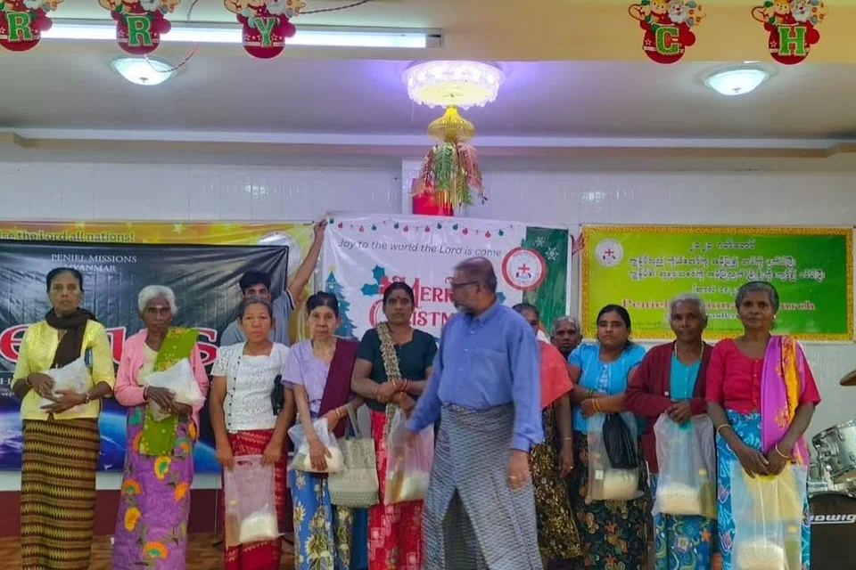 உதவிப் பொருள்களால் வாழ்க்கை நகர்ந்தாலும், தங்கள் வாழ்க்கை வளப்படும் நாள் வெகுதொலைவில் இல்லை என்ற நம்பிக்கையில் இருக்கும் மியன்மார் மக்கள். நடுவில் திரு பால்சன் காலேப்