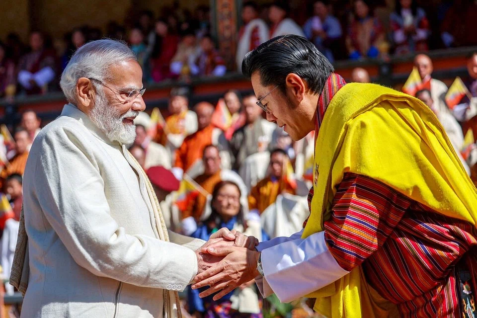 பூட்டான் தலைநகர் திம்புவில், நான்காவது மன்னரின் 70வது பிறந்தநாள் கொண்டாட்ட விழாவில் கலந்துகொண்ட இந்தியப் பிரதமர் நரேந்திர மோடியை வரவேற்கும் பூட்டான் மன்னர் ஜிக்மே கெசர் நாக்யெல் வாங்சுக்.