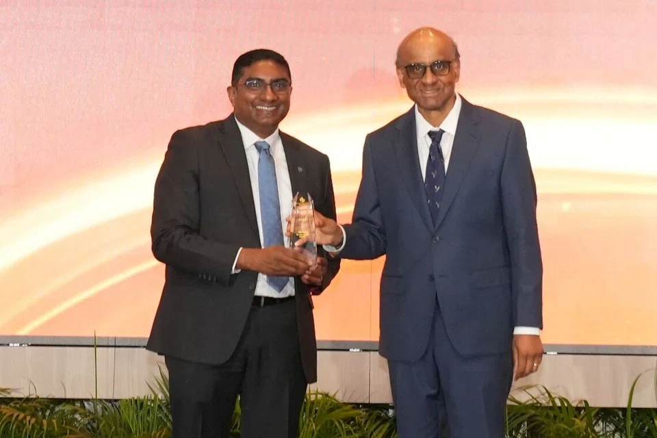 அதிபர் தர்மன் சண்முகரத்னத்திடமிருந்து விருது பெற்றுக்கொண்ட  சிங்கப்பூர் ஏர்லைன்ஸ் பொது விவகாரத் துணைத் தலைவர் சிவா கோவிந்தசாமி.