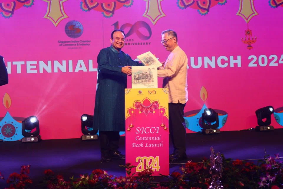 நூலை வெளியிடும் துணைப் பிரதமர் கான் கிம் யோங்குடன் (வலது) சிங்கப்பூர் இந்திய வர்த்தகத் தொழிற்சபையின் தலைவர் நீல் பரேக். 