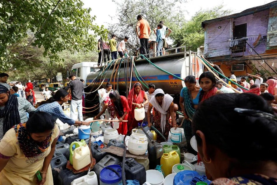 புதுடெல்லி மக்கள் தண்ணீர் லாரியிருந்து குழாய்கள் மூலம்  தண்ணீரைப் பிடித்துச் செல்லும் காட்சி.