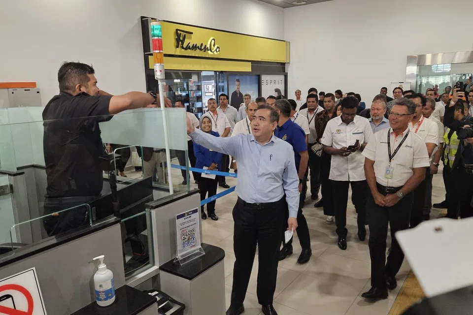 சுபாங் விமான நிலைய குடிநுழைவுத் துறை அதிகாரிகளுடன் கைகுலுக்கும் மலேசியப் போக்குவரத்து அமைச்சர் ஆண்டனி லோக். 