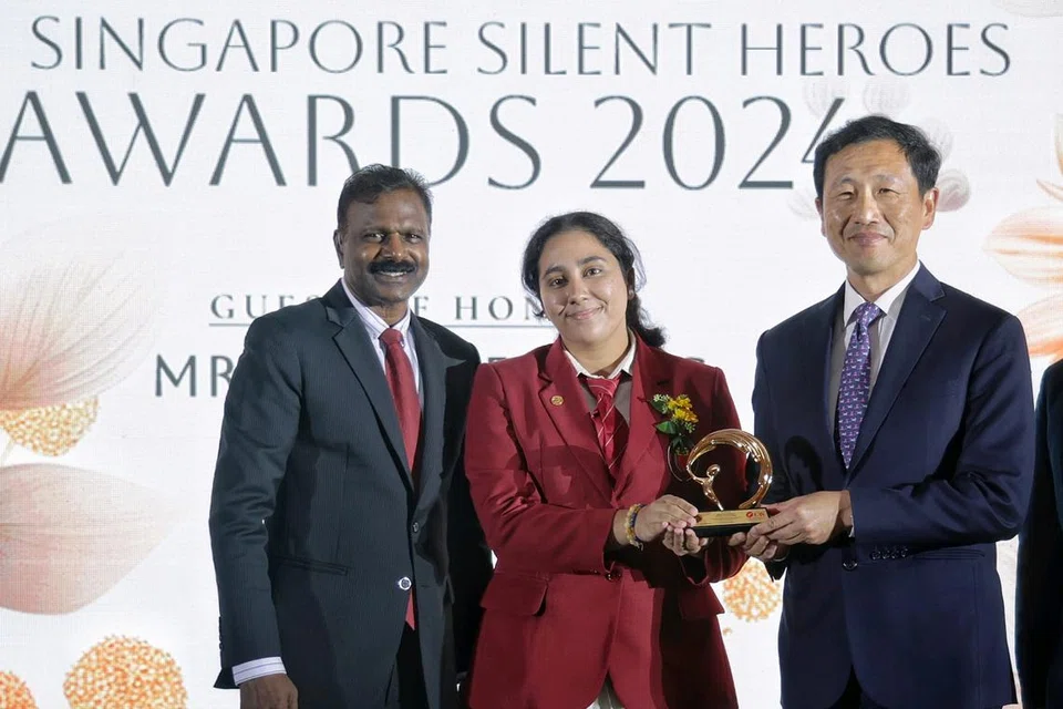 முதன்முறையாக வழங்கப்பட்ட ‘சிங்கப்பூரின் அறியப்படாத நாயகர்கள்’ மாணவ உச்ச (APEX) விருதை சுகாதார அமைச்சர் ஓங் யி காங்கிடமிருந்து பெற்ற நியதி உமாமகேஷ்வர், 17. படத்தில் அவருடன் பொதுமக்கள் கழகத் தலைவர் எம் பி செல்வம் (இடம்). 