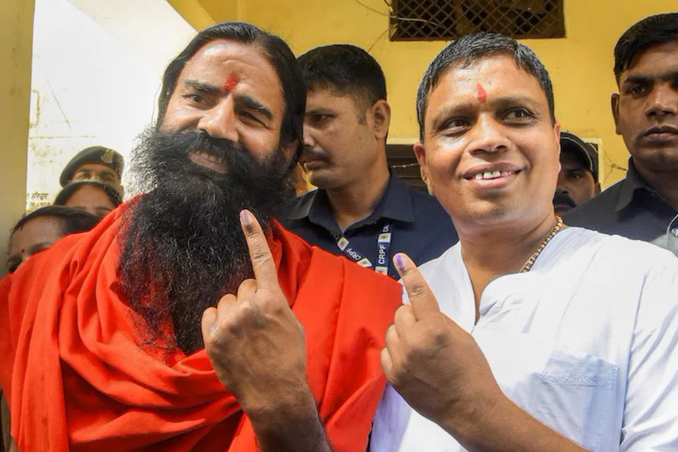 யோகா குரு பாபா ராம்தேவும் (இடது) பதஞ்சலி ஆயுர்வேத நிறுவனத்தின் தலைவர் ஆச்சார்யா பாலகிருஷ்ணாவும்.