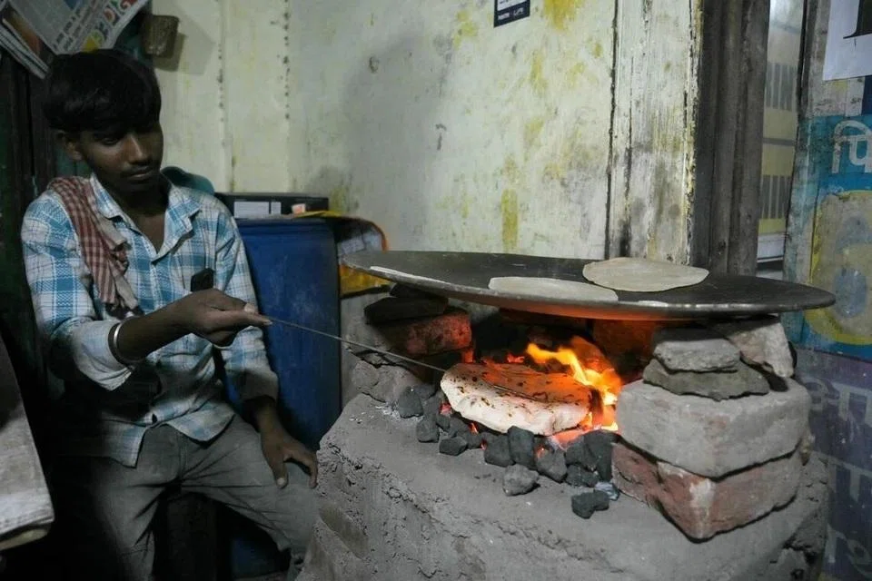 அகமதாபாத்தில் எரிவாயுத் தட்டுப்பாடு காரணமாக நிலக்கரி அடுப்பில் ரொட்டிச் சமைக்கும் ஆடவர். 