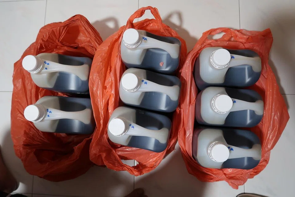 சுவா சூ காங்கில் உள்ள குடியிருப்பு ஒன்றில் கைப்பற்றப்பட்ட சட்டவிரோத இருமல் மருந்து கொள்கலன்கள்.