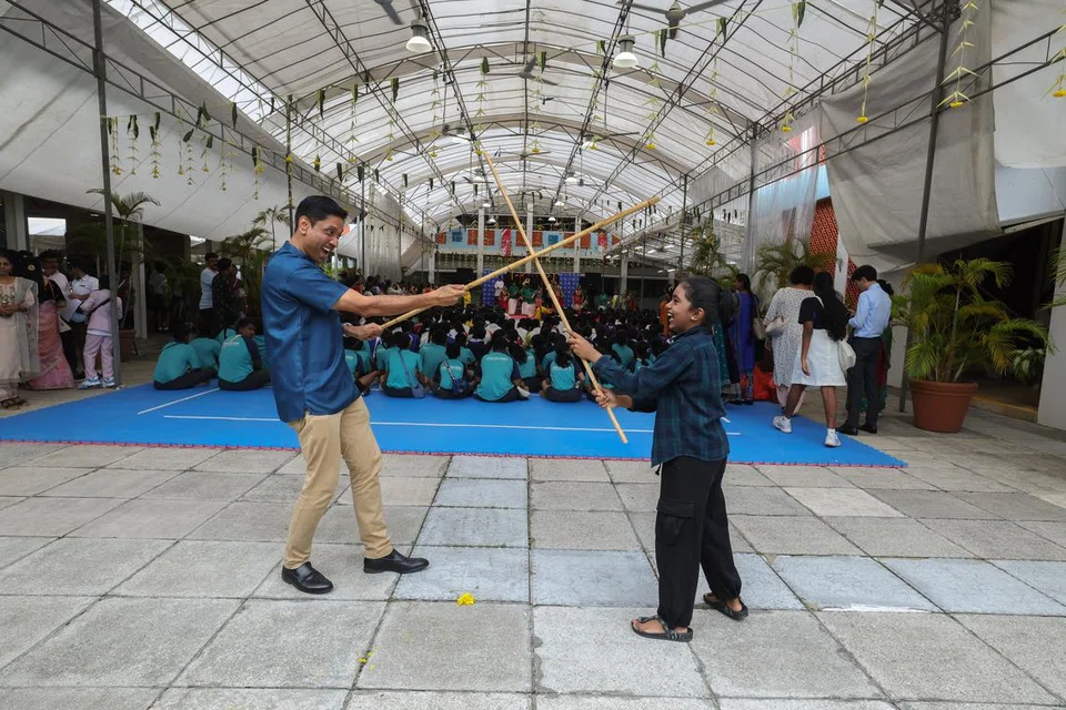 தமிழ்த் திருவிழாவில் மாணவருடன் சிலம்பாட்ட பயிற்சியில் ஈடுபடும் திரு தினே‌ஷ்.