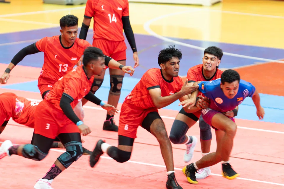 எதிரணியின் தாக்குதலை முறியடிக்கும் சிங்கப்பூர் அணியினர்.