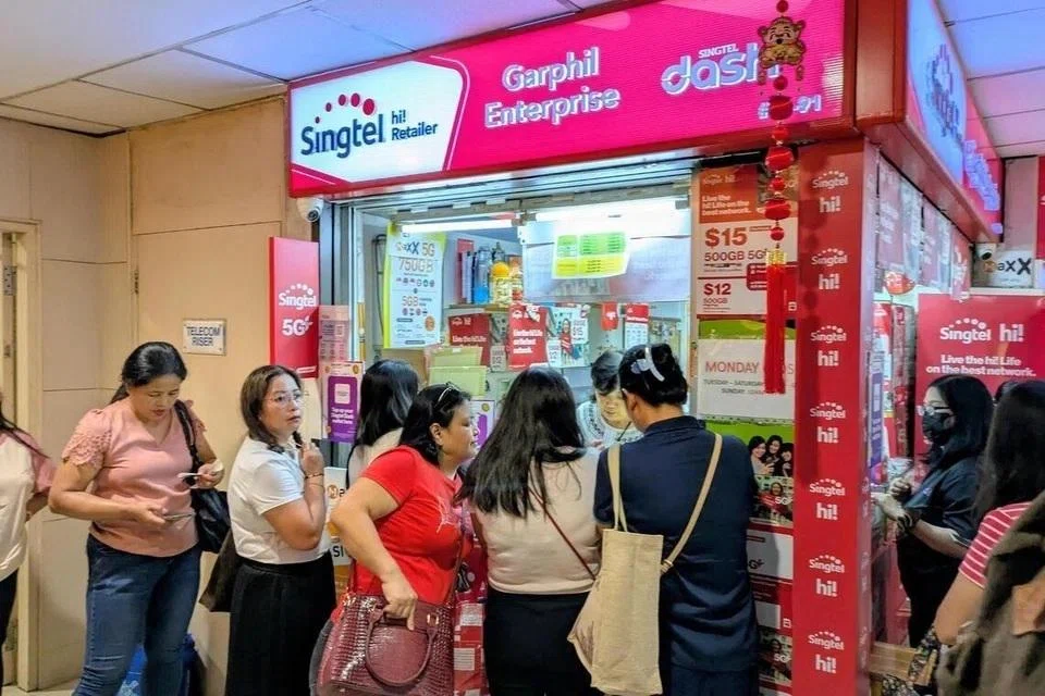 லக்கி பிளாசாவில் உள்ள சிங்டெல் கடையில் சிம் அட்டை இணையத் தொடர்புக்கு கட்டணம் செலுத்துவதற்காகக் காத்திருந்த பணிப்பெண்கள்.