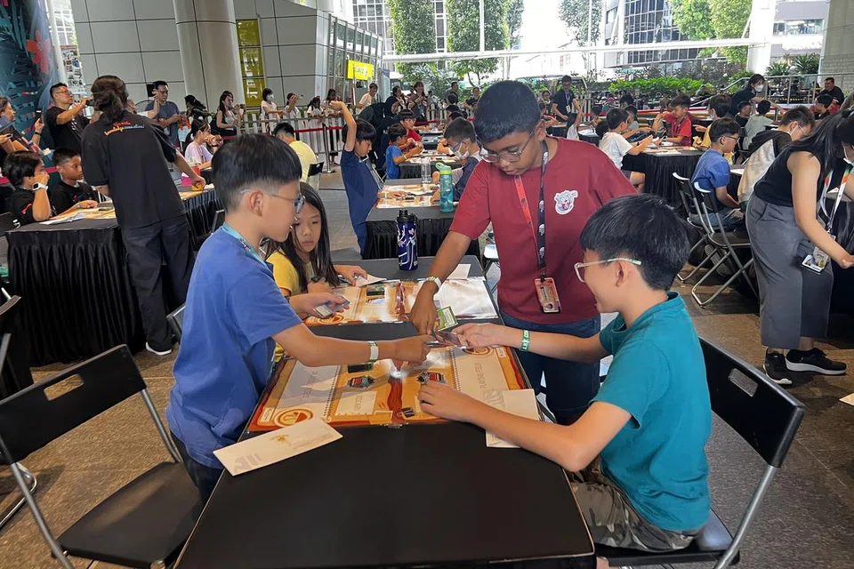 சிறுவர்கள் தமது அட்டைகளை வைத்துப் போட்டிகளிலும் பங்கேற்றனர். படத்தில் சகப் போட்டியாளர்களுடன் குஹன் சிவராம், 12 (சிவப்புச் சட்டையில்).