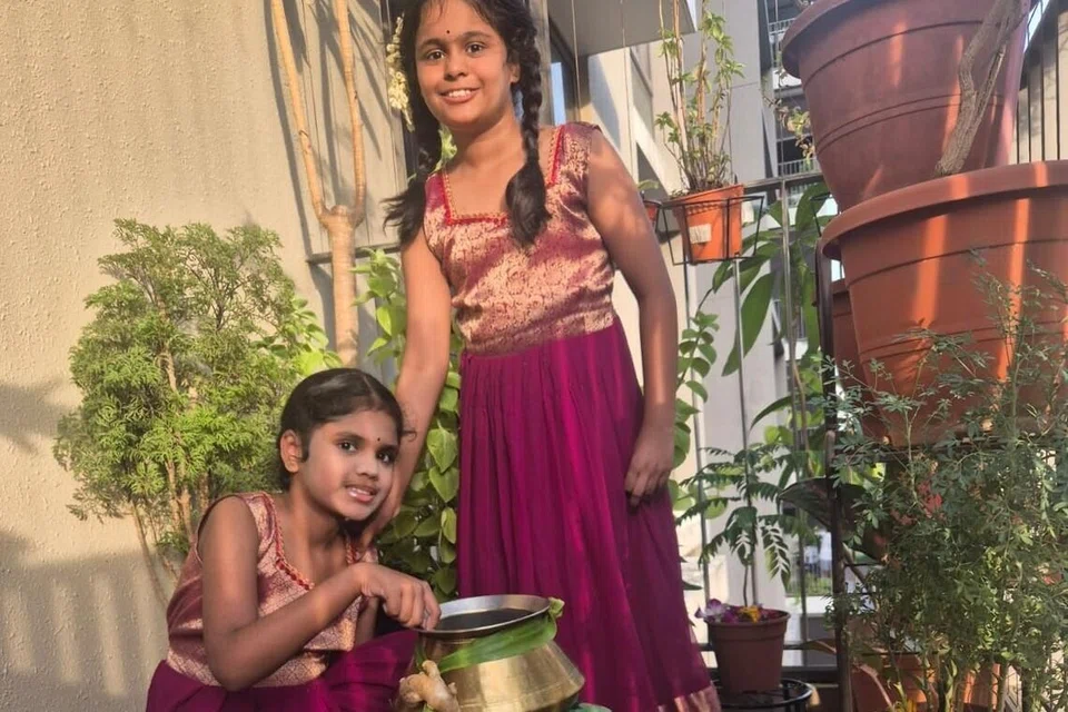 எட்டு வயது இரட்டைச் சகோதரிகள் நவ்யா தேவி சதீஷ், நேத்ரா தேவி சதீஷ் பொங்கல் அலங்காரங்களைச் செய்கின்றனர்.