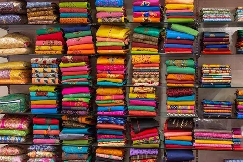 விற்பனைக்கு அடுக்கி வைக்கப்பட்டுள்ள புடவைகள், ஆடைகள்.