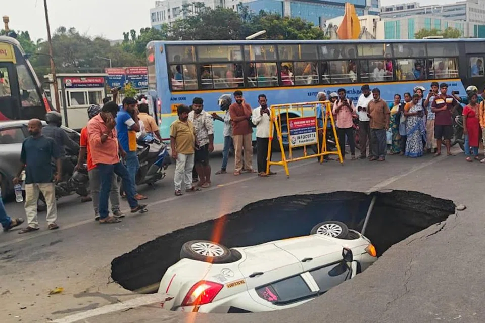 சாலையில் ஏற்பட்ட பள்ளத்தில் கார் கவிழ்ந்து விபத்தில் சிக்கியது. பின்னர், கிரேன் மூலம் காரைத் தூக்கி அப்புறப்படுத்தினர்.