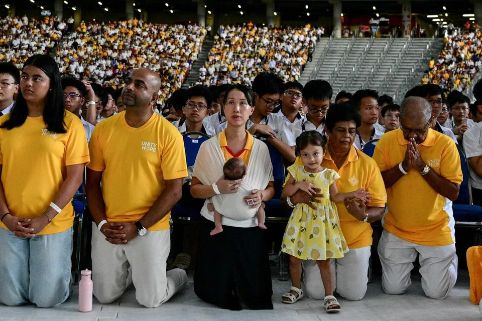 Catholic faithful attend the holy mass being led by Pope Francis at the National Stadium in Singapore on September 12, 2024. (Photo by Tiziana FABI / AFP)