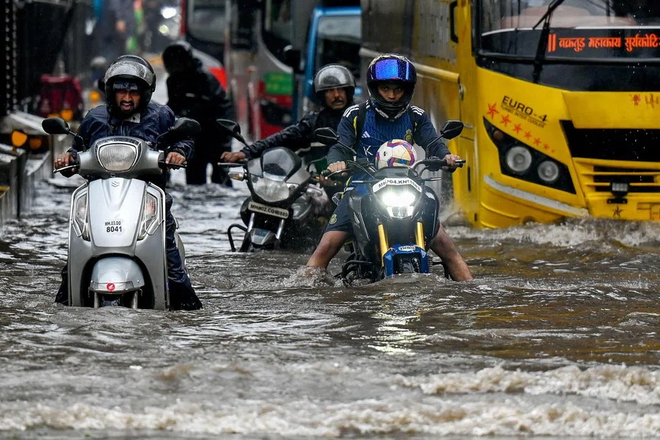 வெள்ளநீரில் மூழ்கியுள்ள சாலையில் ஊர்ந்தபடி செல்லும் வாகன ஓட்டிகள்.