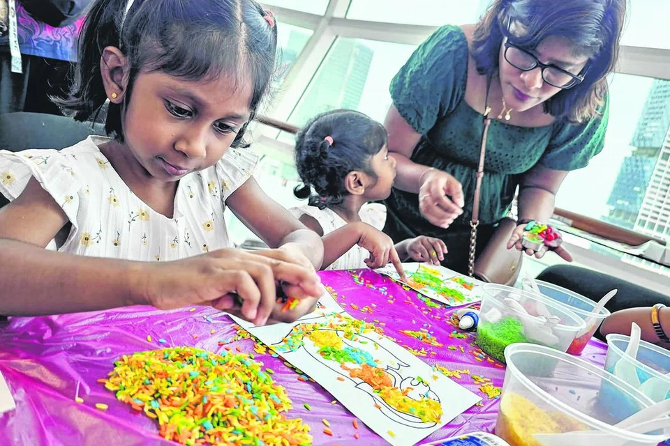 சிறுவர்கள் வண்ண மணிகளைக் கொண்டு படத்தை அழகுபடுத்துகிறார்கள்.  