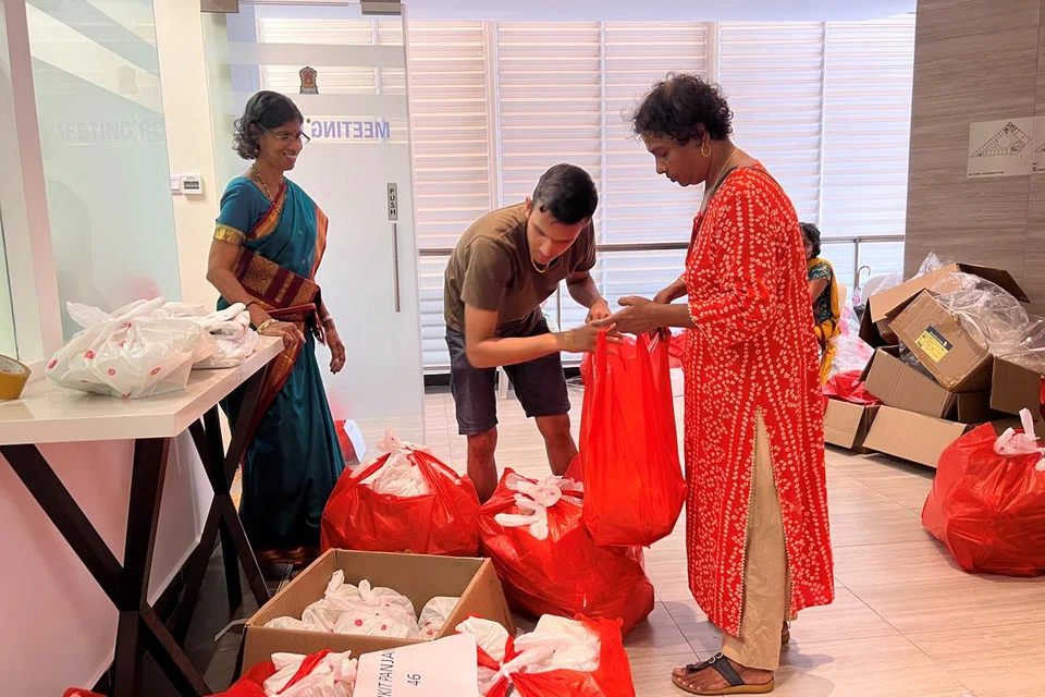 உணவுப் பொட்டலங்களை அடுக்கும் தொண்டூழியர்கள்.