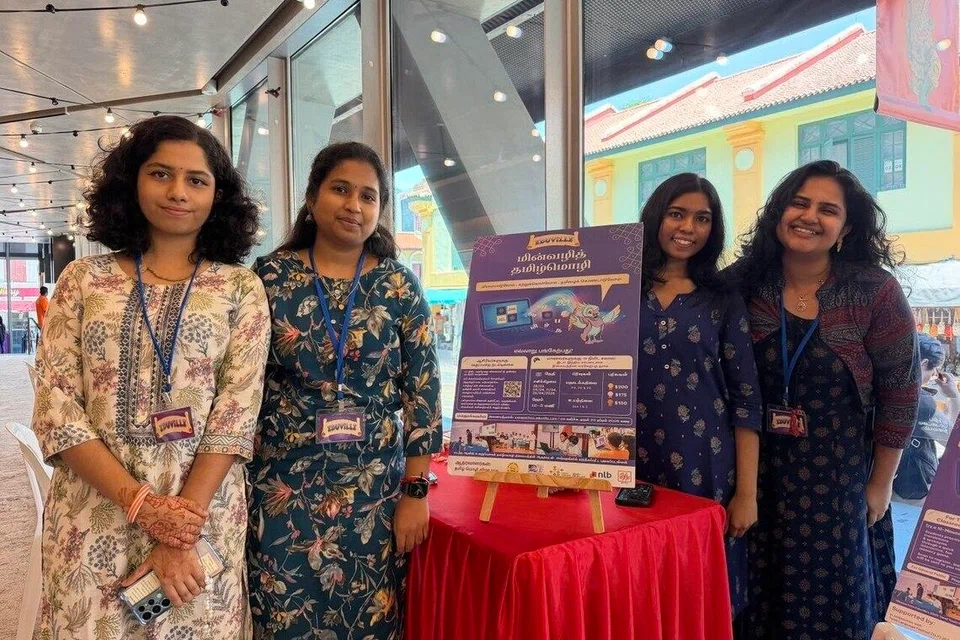 ‘எடுவில்’ (Eduville) மின்வழித் தமிழ்மொழிக் கண்காட்சிக் கூடத்தில் புன்னகையுடன் நிற்கும் தொண்டூழியர்கள்.