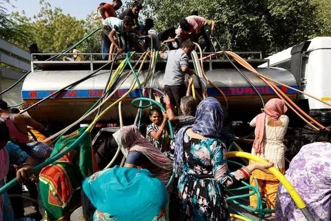 குடிநீர் லாரியிலிருந்து நீரைத் தங்கள் பாத்திரங்களில் நிரப்பும் புதுடெல்லிவாசிகள்.