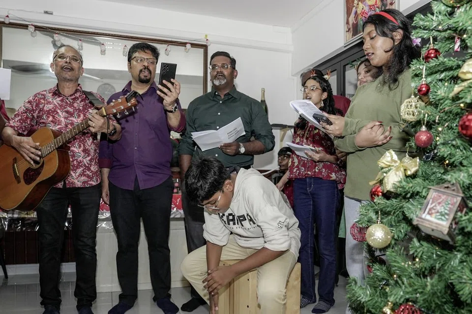 திரு ஜேம்ஸ் ராஜ் (நடுவில்), 42, கிறிஸ்துமஸ் பண்டிகையை முன்னிட்டுக் கடந்த பத்தாண்டுகளாகத் தன் வீட்டுக்குப் பாடல் குழுக்களை வரவேற்கிறார். 