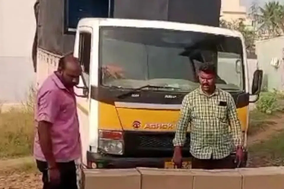 பறிமுதல் செய்யப்பட்ட லாரியும் மதுப்புட்டிகளும்.
