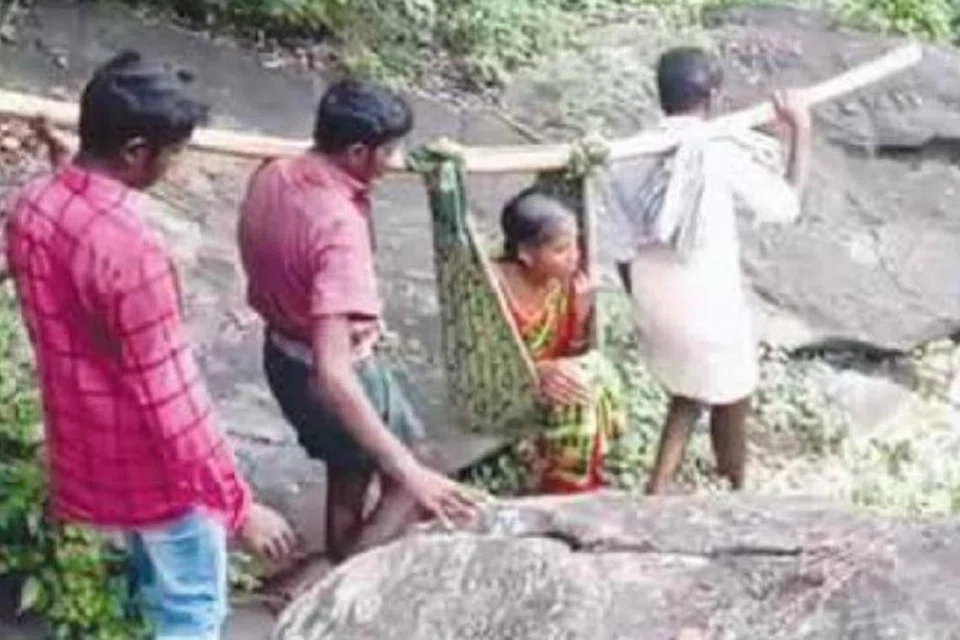 உடுமலைக்கு அருகேயுள்ள குழிப்பட்டியில் இருந்து உடுமலை மருத்துவமனைக்கு நோயாளி ஒருவரை தொட்டில் கட்டித் தூக்கிச் செல்லும் உறவினர்கள்.