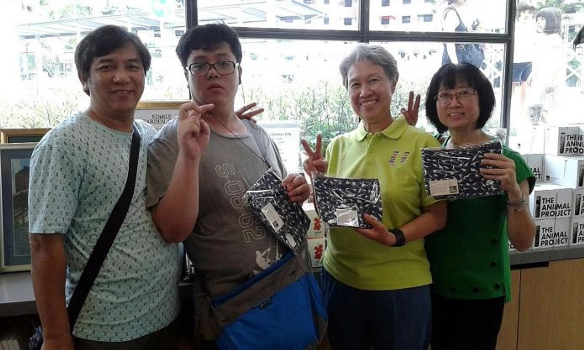 GOOD CAUSE: See Toh Sheng Jie (second from left) with his parents and Ms Ho Ching, who is holding the dinosaur pouch he designed. 