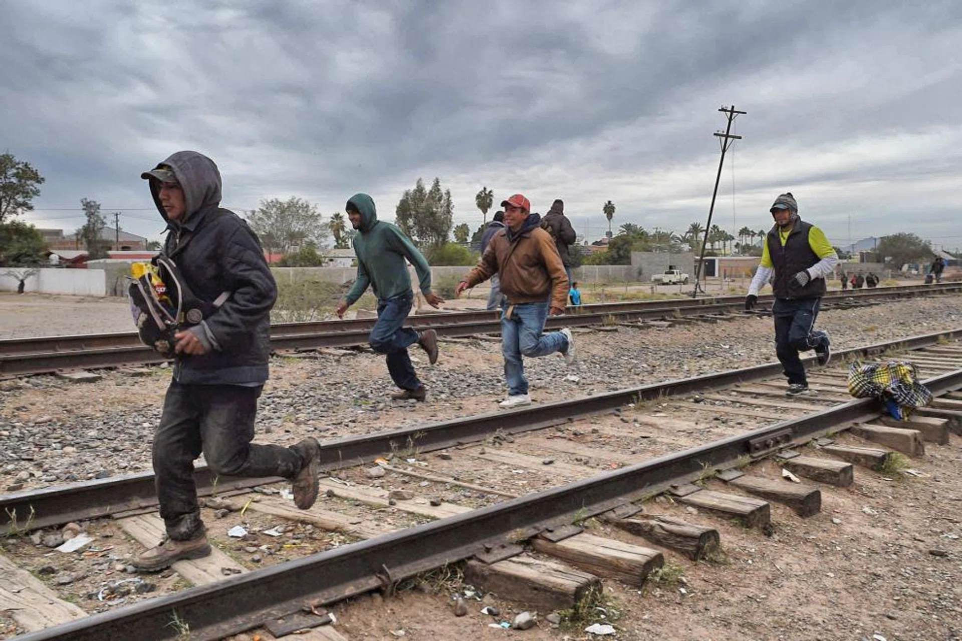 Migrants running to receive food as they attempt to cross the US border.