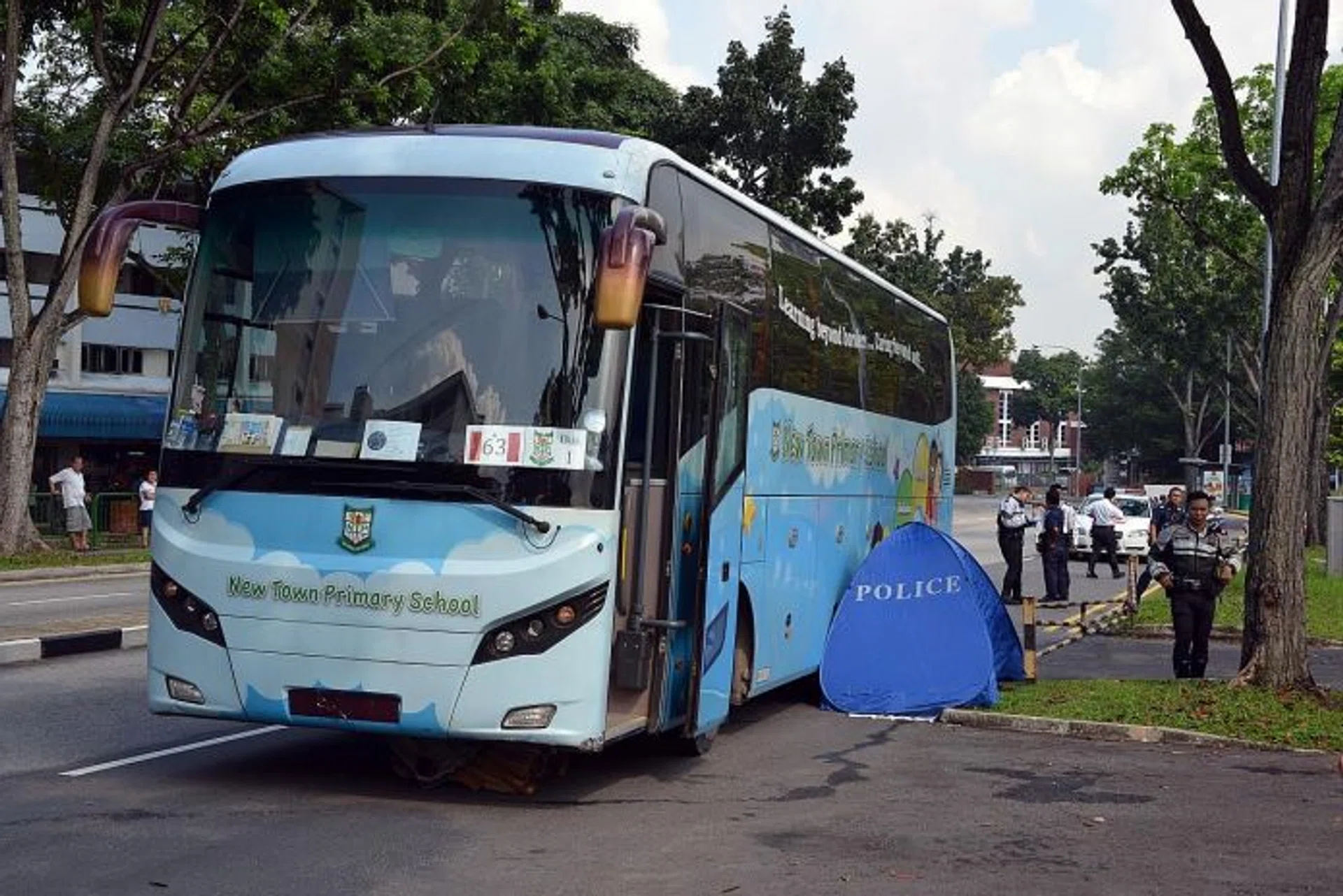 DRAGGED: The bus driven by Mr Oh Chin Chai at the scene of the accident at Marsiling Lane. The body tent was set up on the left side of the bus, but Madam Ching Guan Eng's body was extricated from the rear right tyre of the bus.
